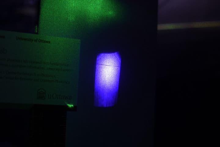 The shadow of a laser beam can be seen as the small dark line across the blue light