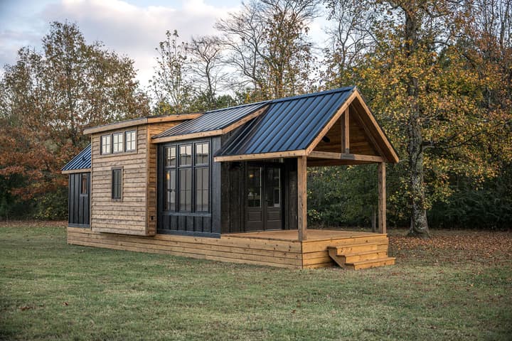 The Hidden Mountain Tiny Villa has a wooden exterior and features a large porch area