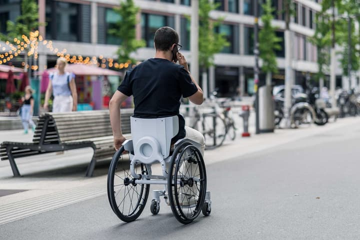 Users of the wheelchair can both steer and propel the chair forward while still keeping one hand free for other tasks